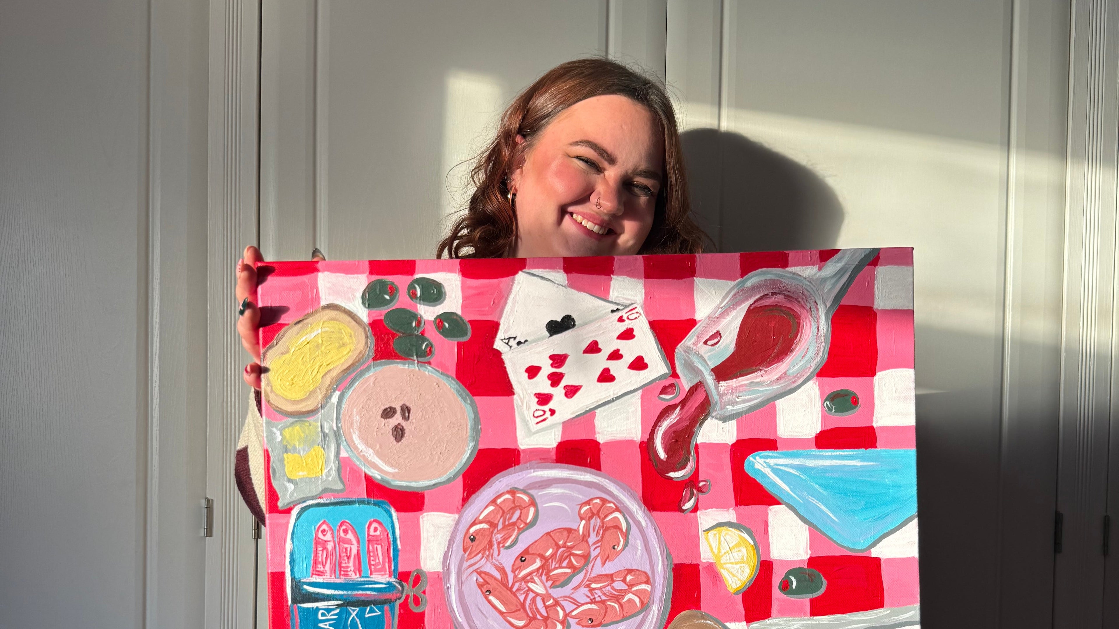 Person holding painting of colourful food themed illustrations